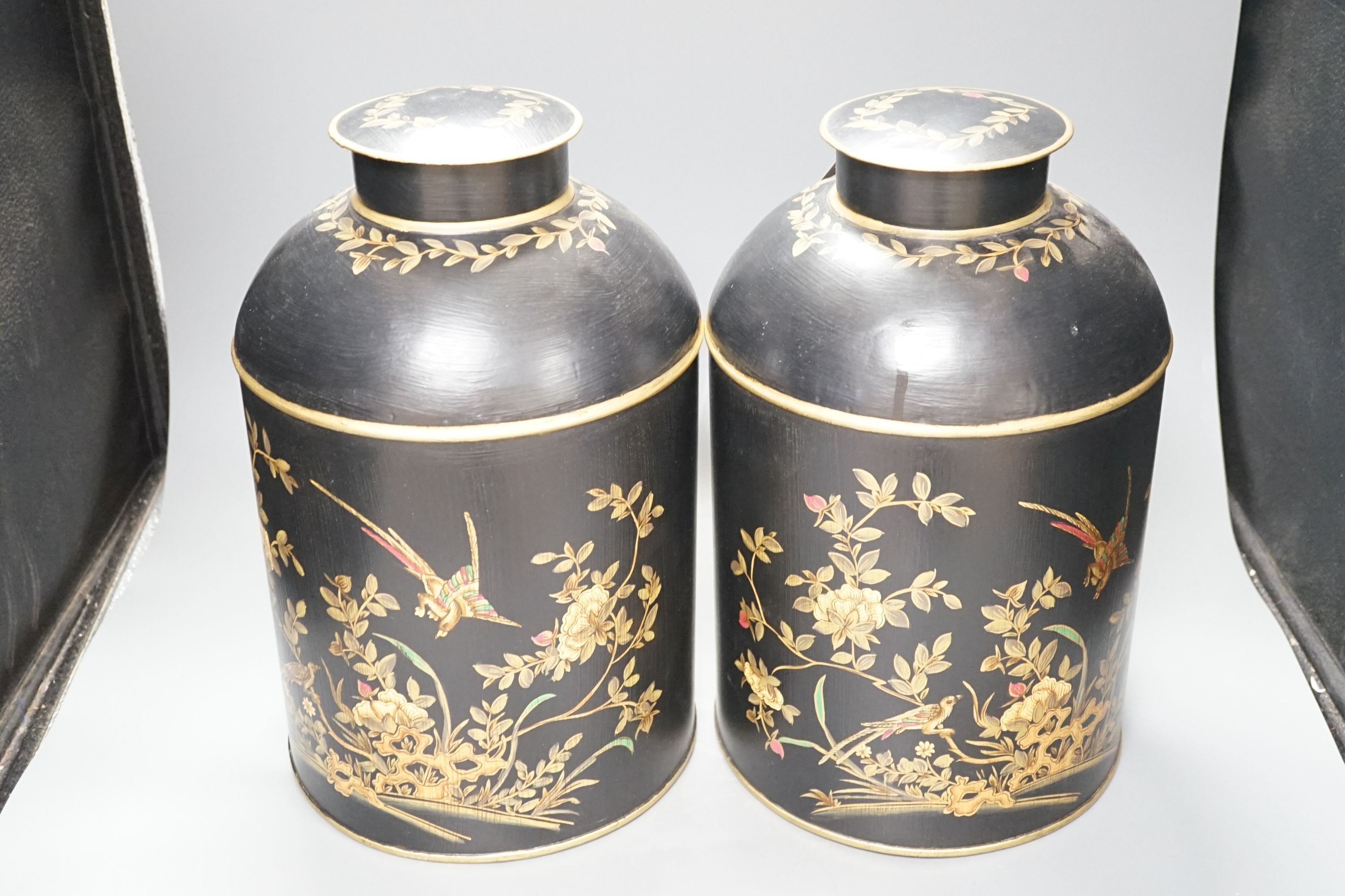A pair of toleware style tea cannisters, 36 cms high.